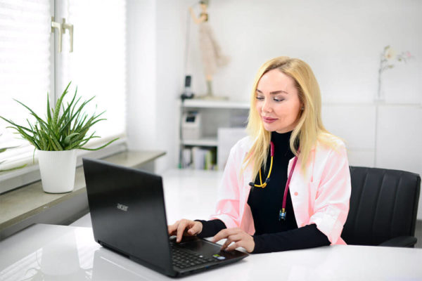 needling_dermapen Frau Zaslavskij am Laptop